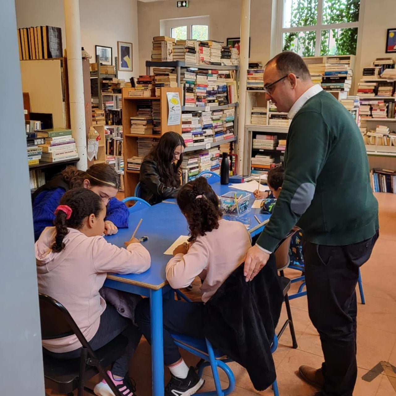 Eric Coudert anime un atelier créatif avec des enfants, combinant coloriage et activités d’écriture pour stimuler leur imagination et partager un moment de complicité.